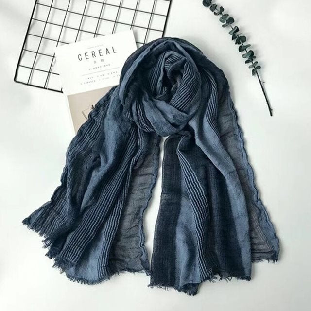 Solid long scarf draped over women's shoulders outdoors