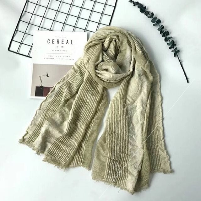 Solid long scarf draped over women's shoulders outdoors