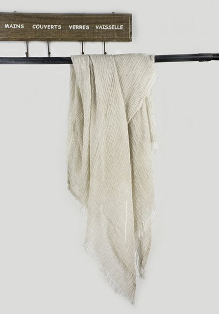 Solid long scarf draped over women's shoulders outdoors