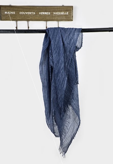 Solid long scarf draped over women's shoulders outdoors