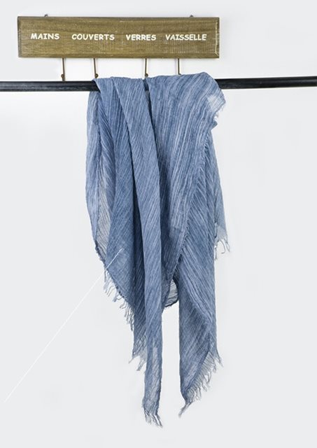 Solid long scarf draped over women's shoulders outdoors