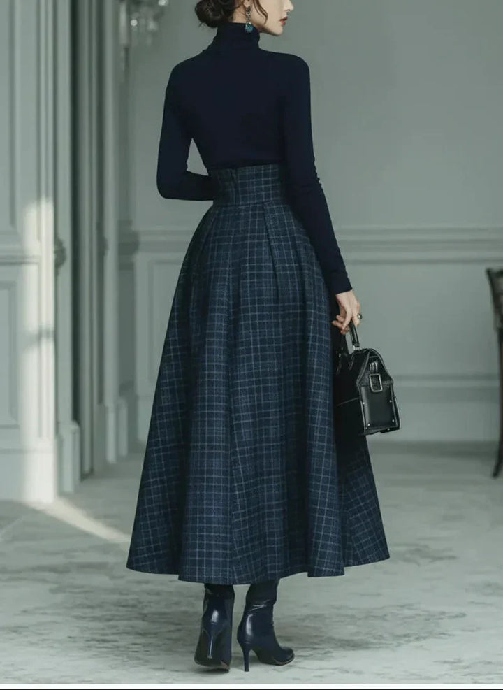 Woman wearing dark blue high-neck top and plaid skirt set