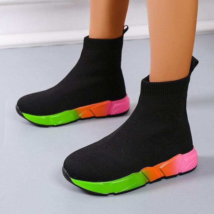 Woman wearing black and pink platform ankle boots