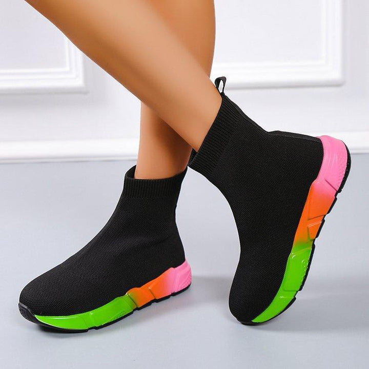 Woman wearing black and pink platform ankle boots