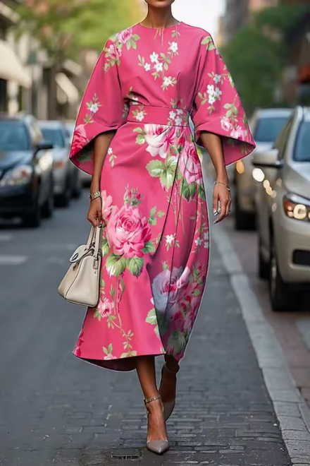 Woman wearing pink and green floral summer dress outdoors