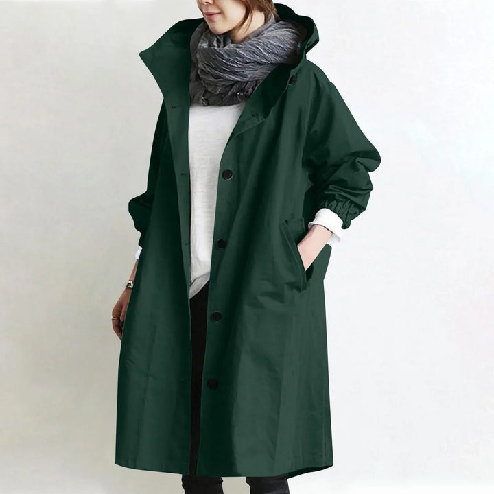Woman wearing a hooded longline trench coat with button front