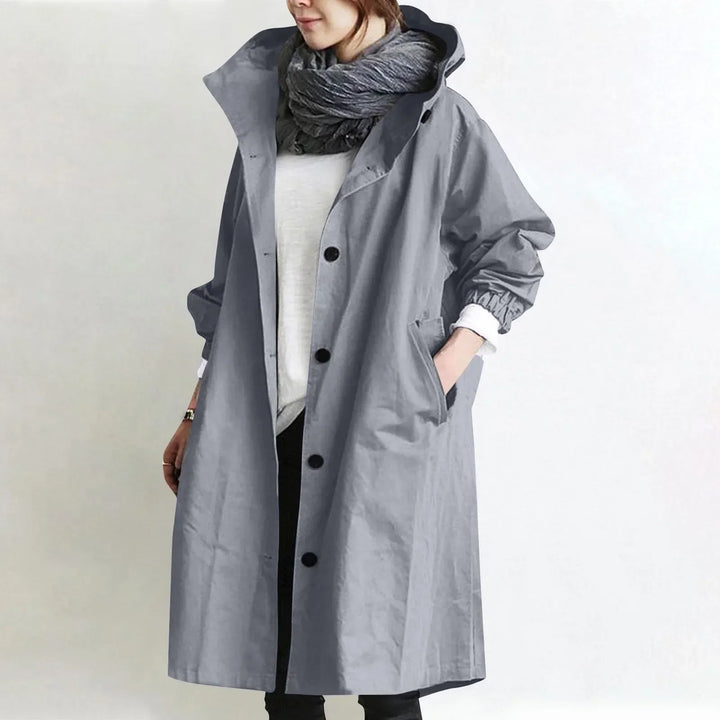 Woman wearing long hooded coat with button front