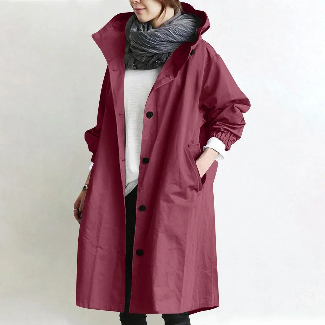 Woman wearing long hooded coat with button front