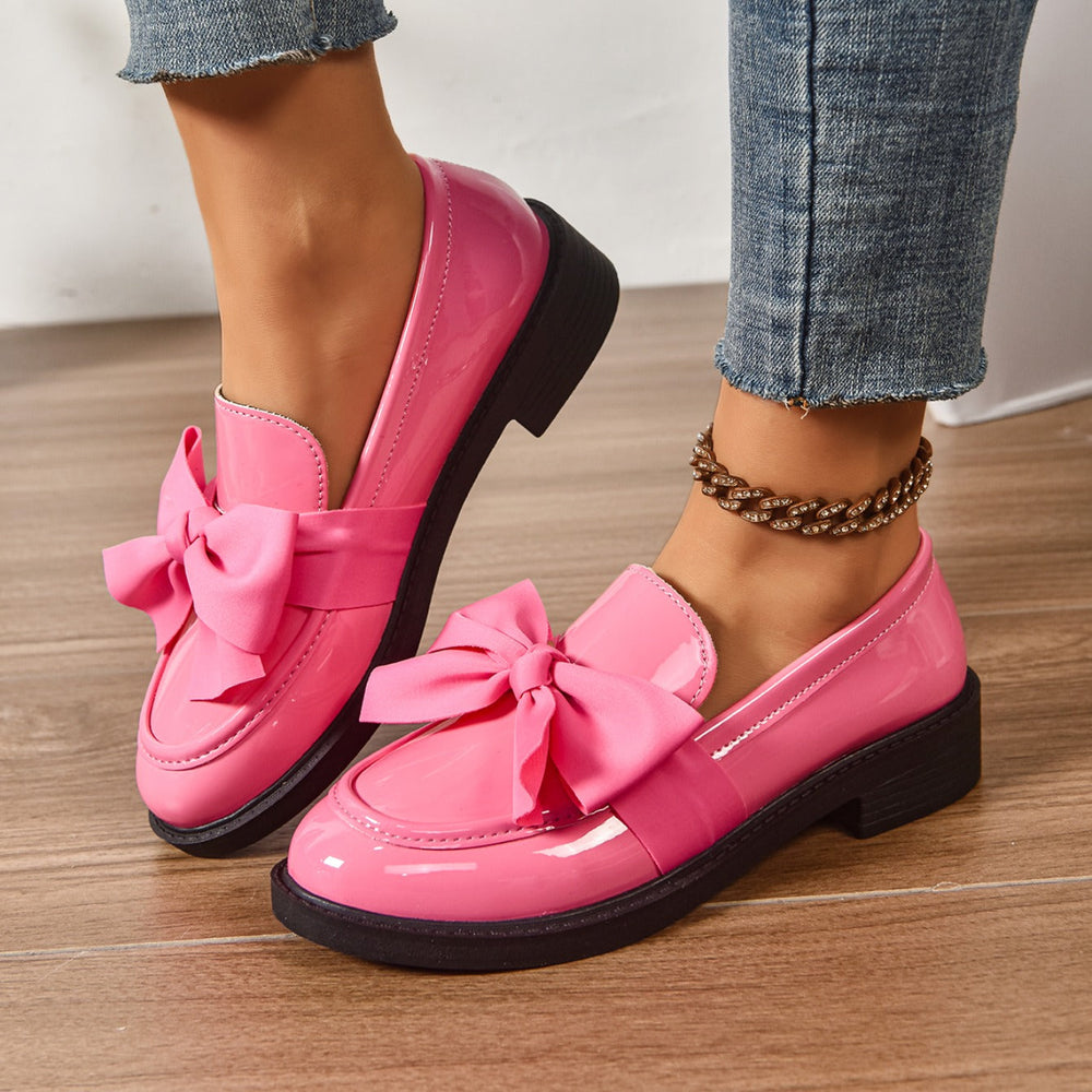 Women's pink bow loafers with classic moc-toe shape