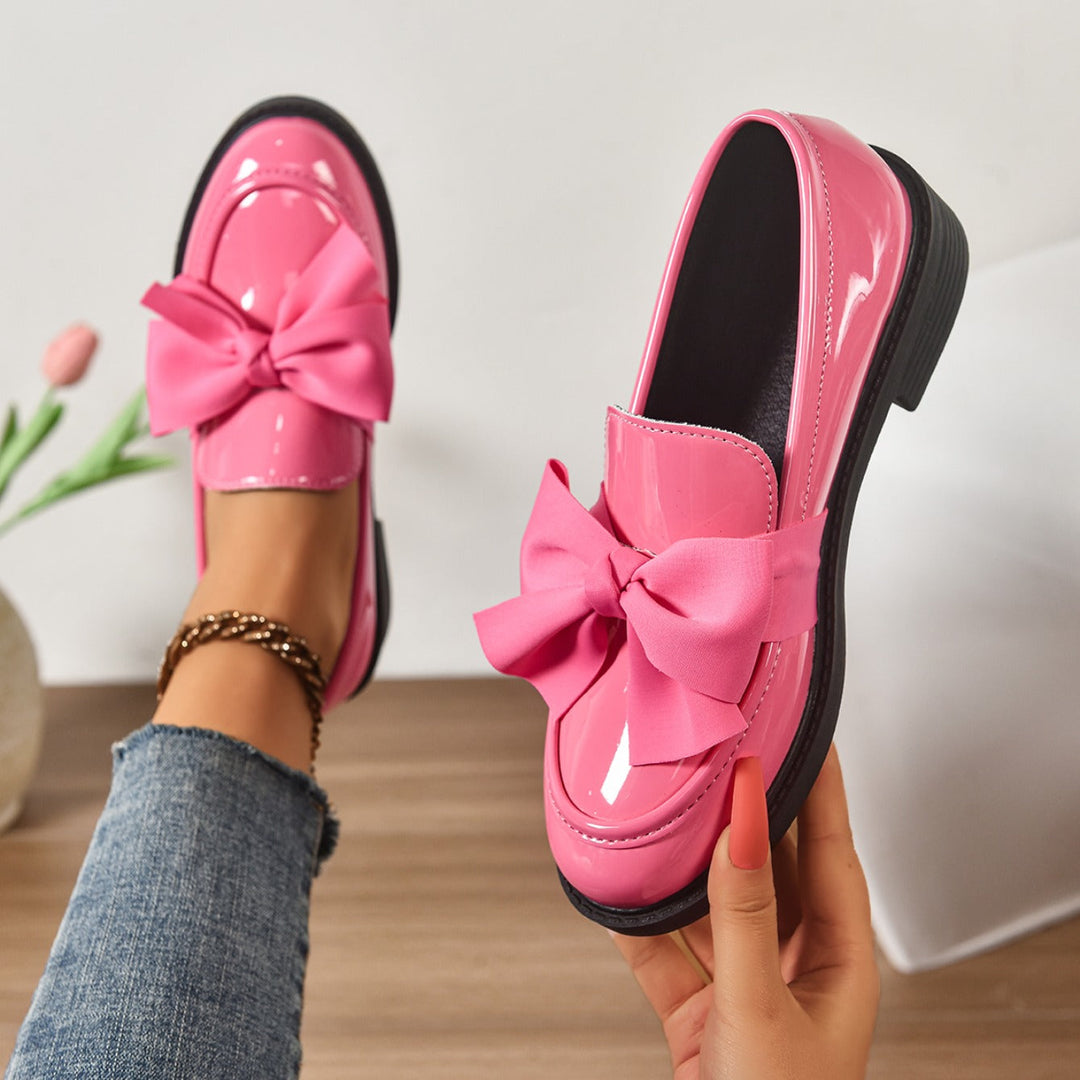 Women's pink bow loafers with classic moc-toe shape