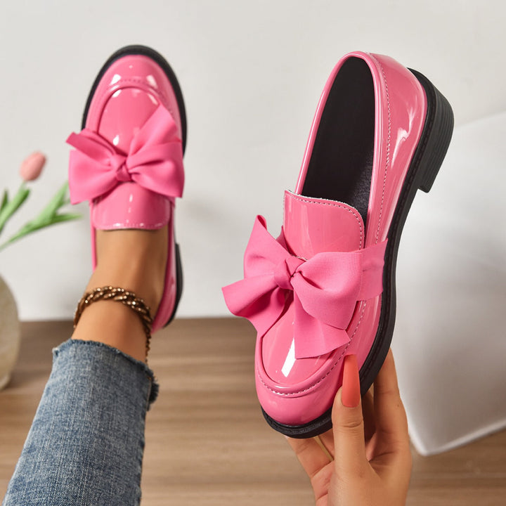 Women's pink bow loafers with classic moc-toe shape