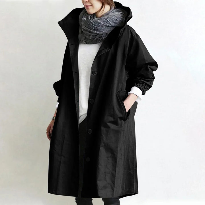 Woman wearing a hooded longline trench coat with button front