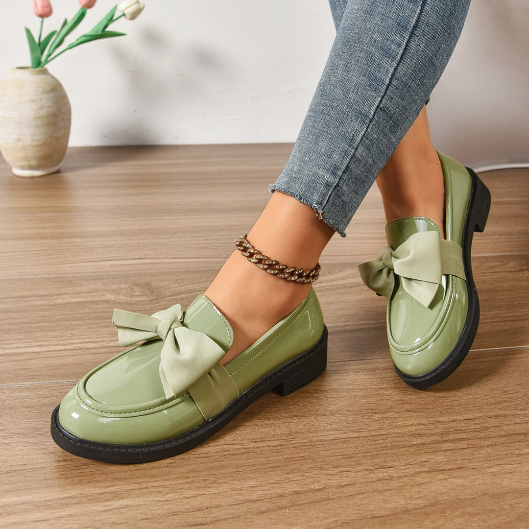 Women's pink bow loafers with classic moc-toe shape