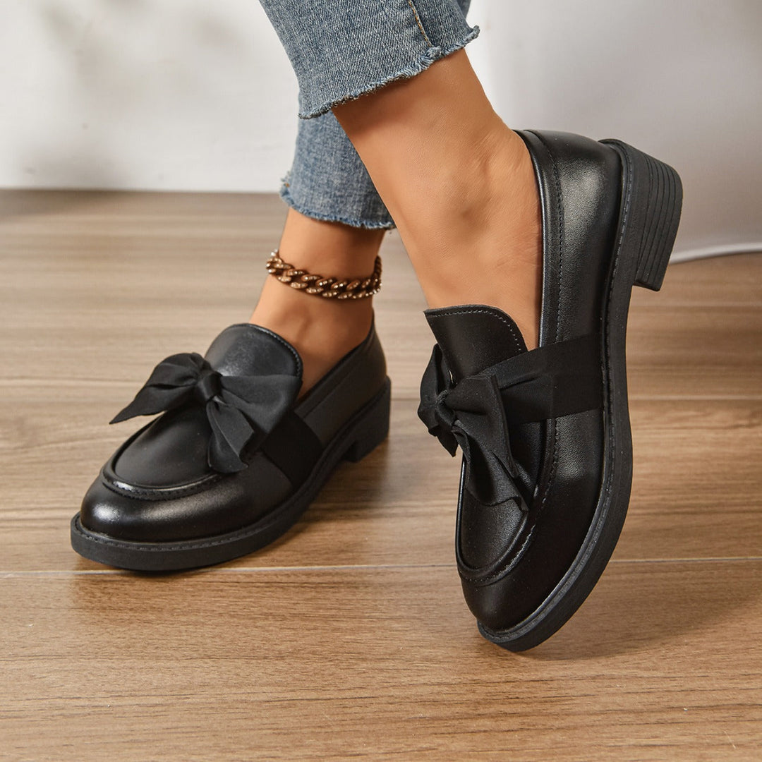 Women's pink bow loafers with classic moc-toe shape