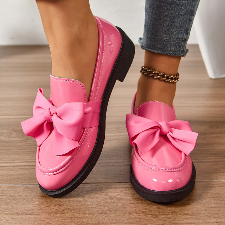 Women's pink bow loafers with classic moc-toe shape