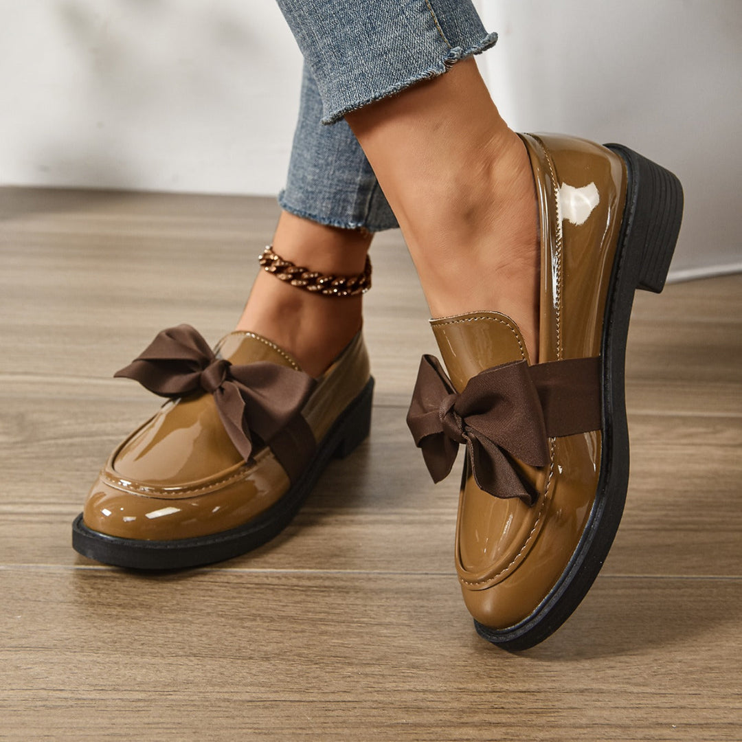 Women's pink bow loafers with classic moc-toe shape