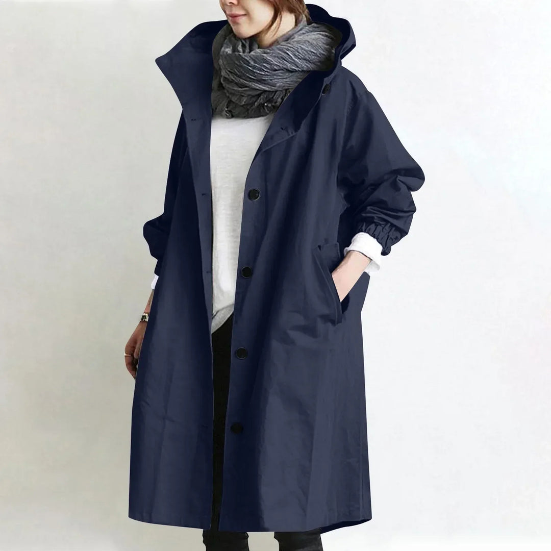 Woman wearing a hooded longline trench coat with button front