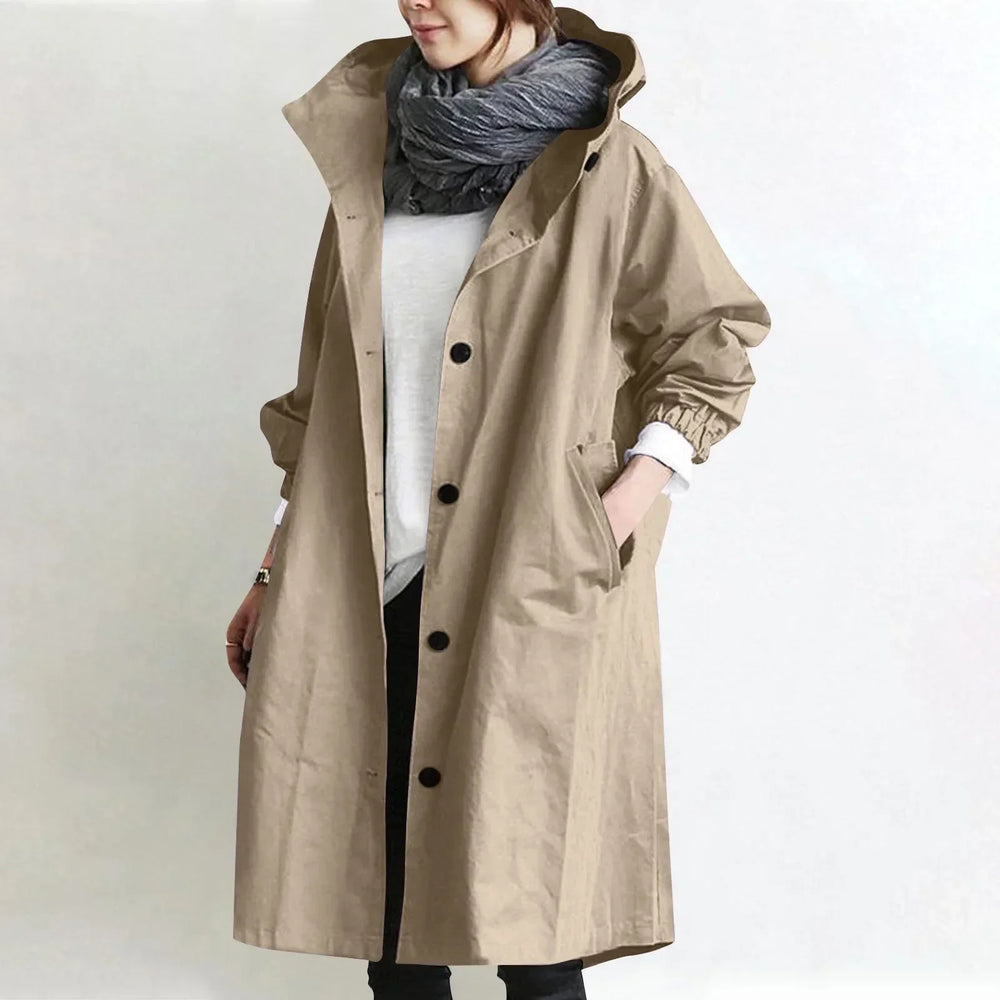 Woman wearing a hooded longline trench coat with button front