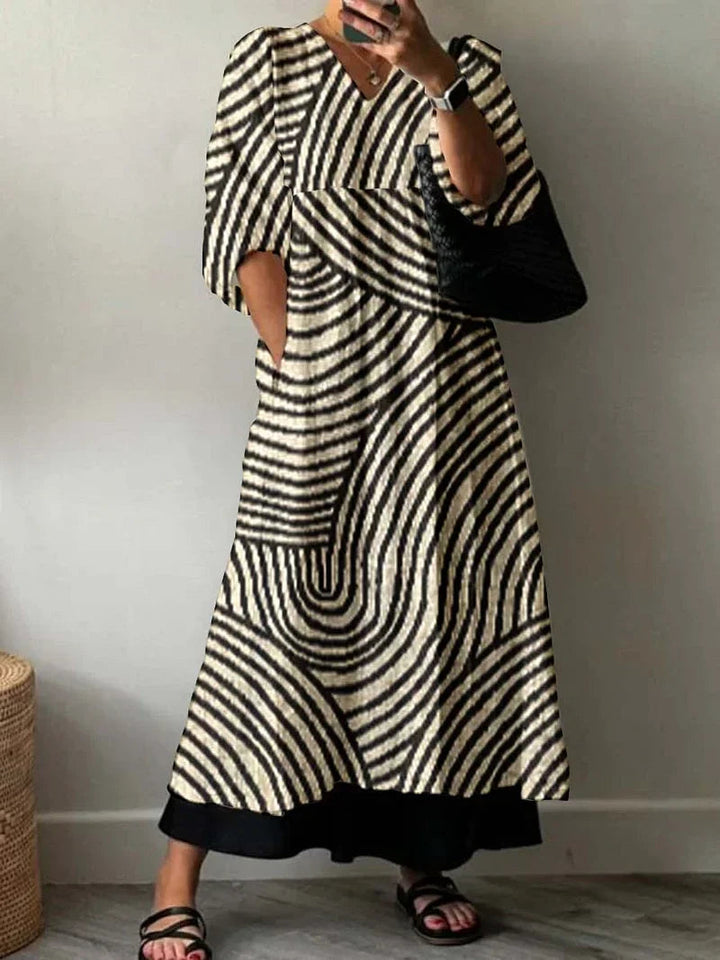 Woman wearing a flowy summer maxi dress with geometric print