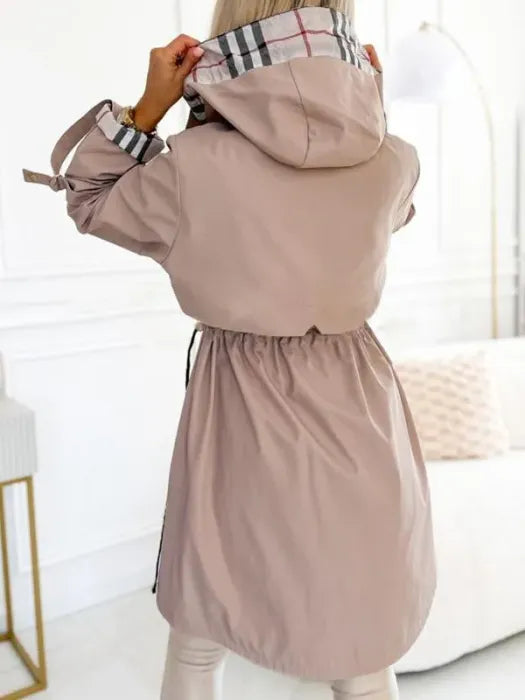 Woman wearing long coat with checked hood